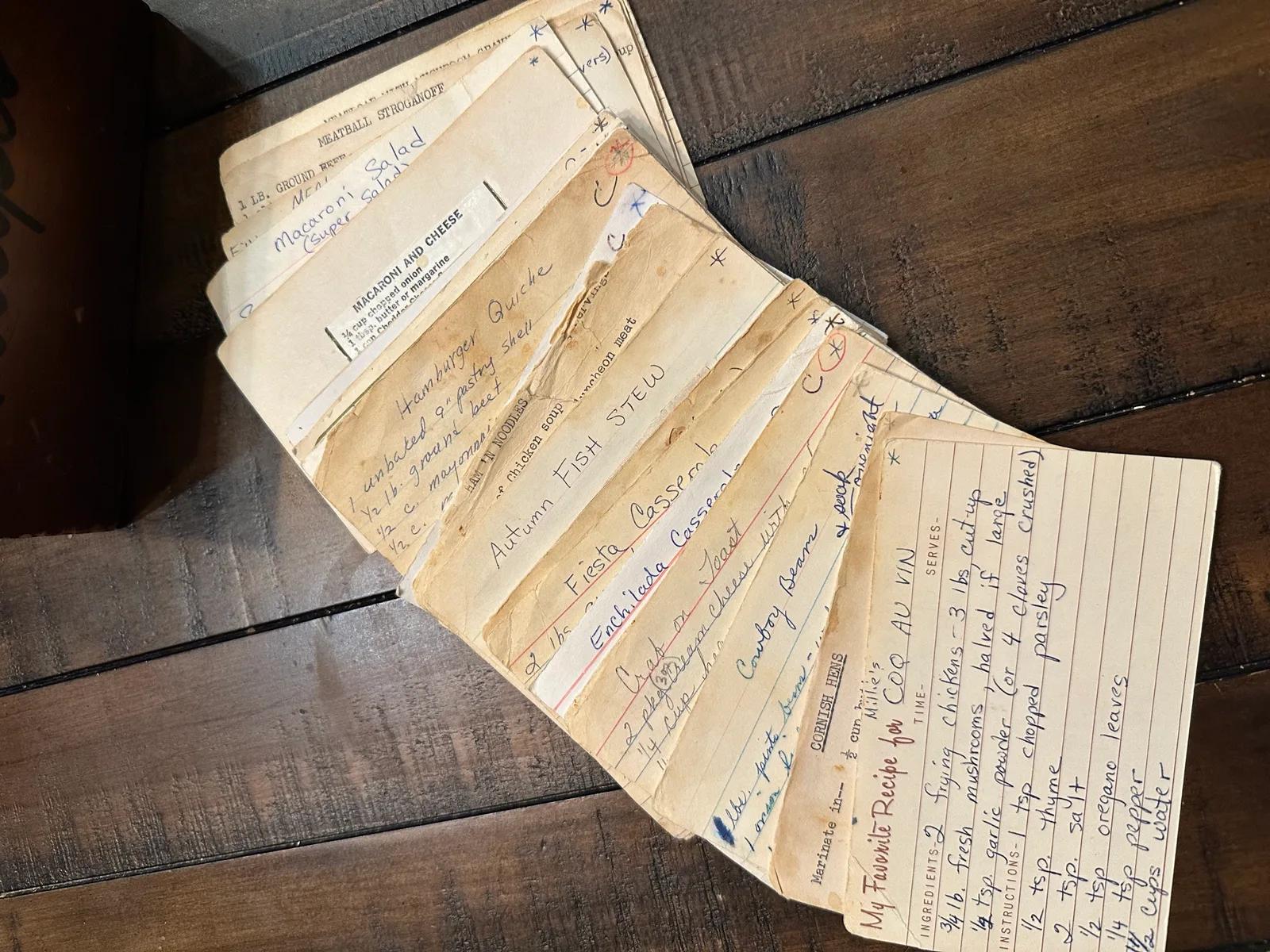 Handwritten heirloom recipe cards fanned out on a wooden table